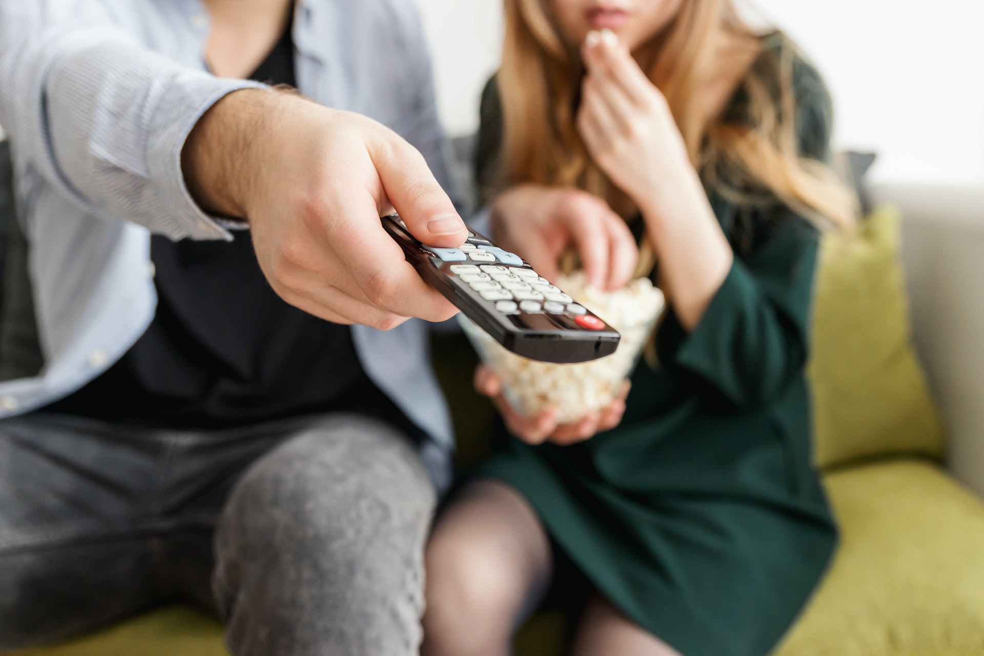 two people watching tv with popcorn in their luxury apartment