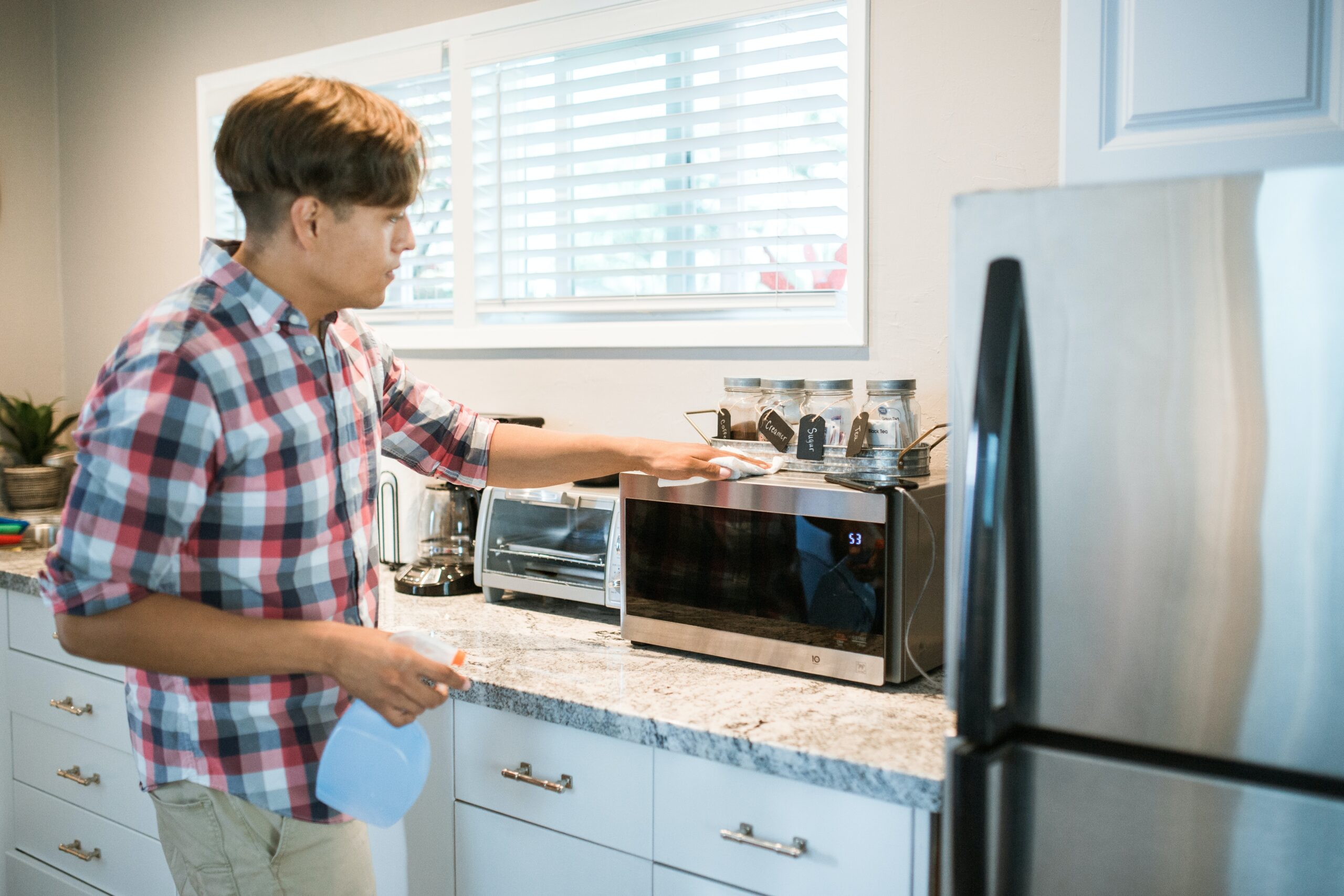 person cleaning microwave in apartment