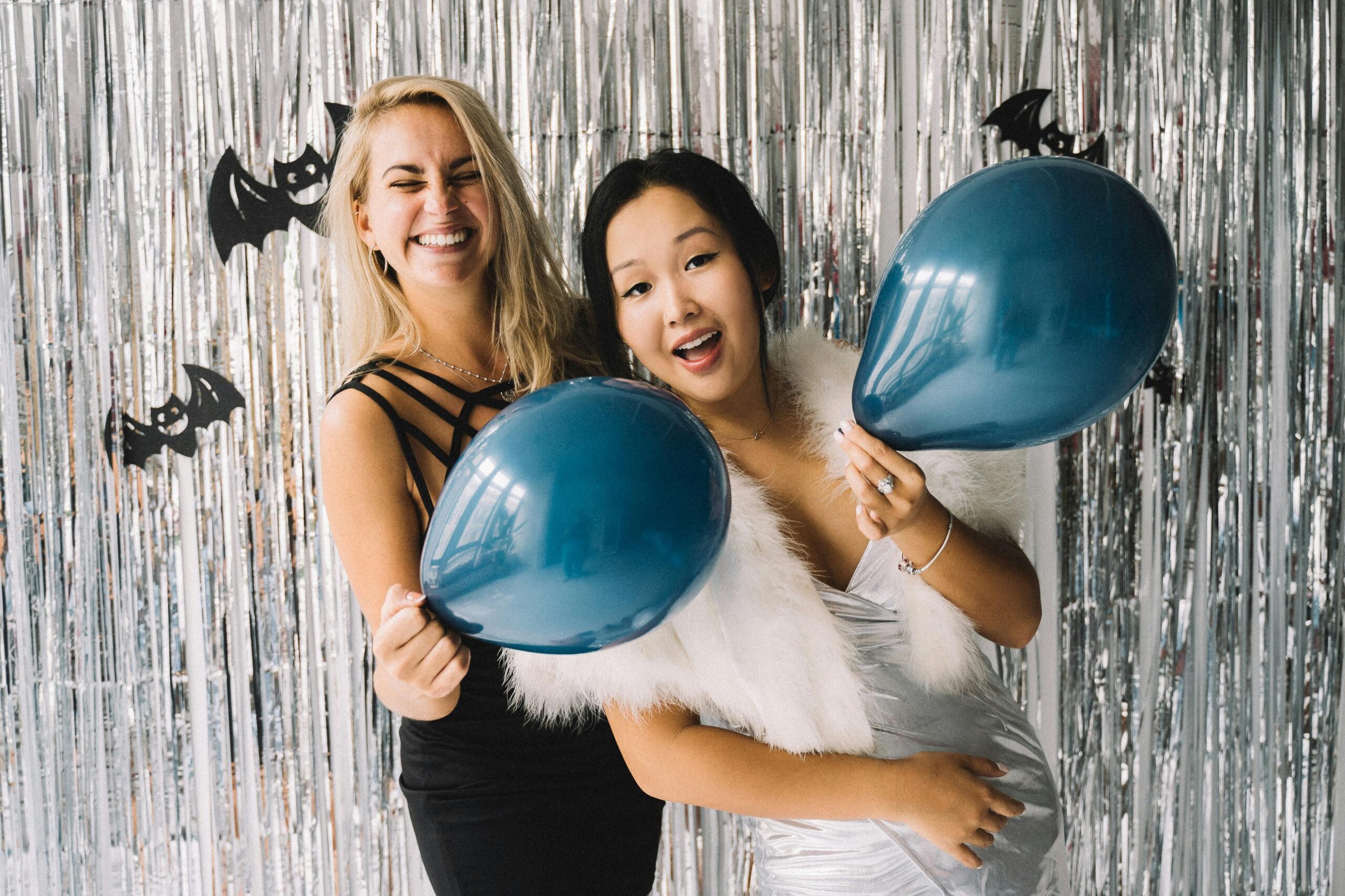 two girls at halloween party holding balloons in costumes rpm apartments blog